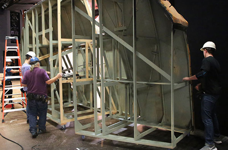 Jon Lagerquist, center, works with other staff member loading in the set for Quixote Nuevo.